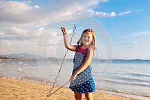 Kids blow bubble at beach. Child with bubbles