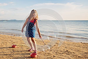 Kids blow bubble at beach. Child with bubbles