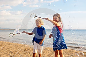 Kids blow bubble at beach. Child with bubbles