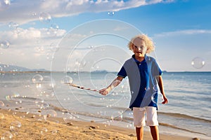 Kids blow bubble at beach. Child with bubbles