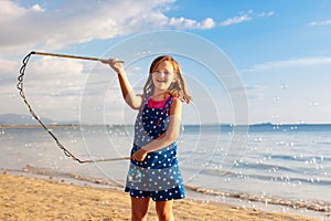 Kids blow bubble at beach. Child with bubbles