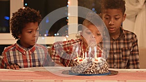 Kids blowing cake's candles out.