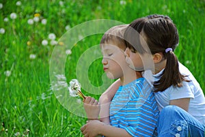 Kids blowing dandelion seeds