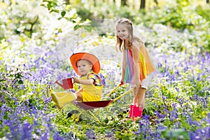Kids with bluebell flowers, garden tools