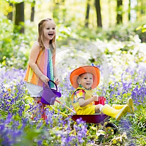 Kids with bluebell flowers, garden tools