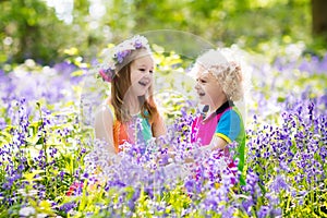 Kids with bluebell flowers, garden tools