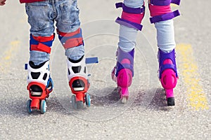 Kids boy and girl having fun outdoor while riding roller skates. Children on rollerblades. Roller skating in the park near