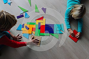 Kids-boy and girl- playing with puzzle, doing tangram