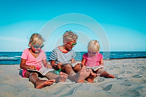 Kids -boy and girls- reading books at beach vacation