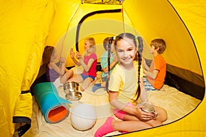 Kids, boys and girls play in camping tent