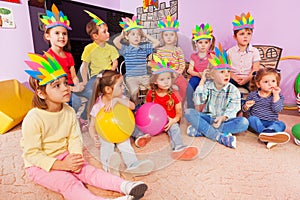 Kids boys and girls sit in circle with toys