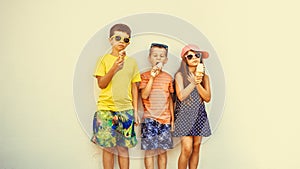 Kids boys and little girl eating ice cream.