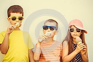 Kids boys and little girl eating ice cream.