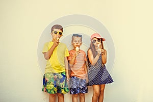 Kids boys and little girl eating ice cream.