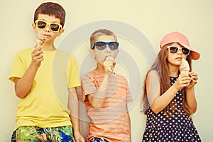 Kids boys and little girl eating ice cream.