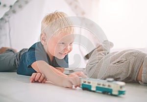 Kids brothers are laying on the floor. Boys are playing in home with toy cars at home in the morning. Casual lifestyle