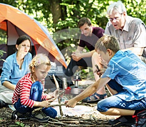 Kids building a camp fire in family camping trip