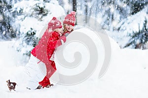 Kids building snowman. Children in snow. Winter fun.