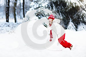 Kids building snowman. Children in snow. Winter fun.