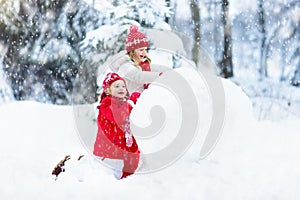 Kids building snowman. Children in snow. Winter fun.