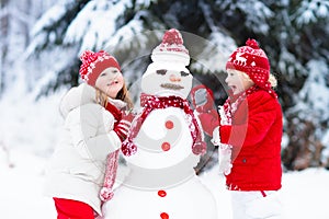 Kids building snowman. Children in snow. Winter fun.