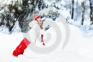 Kids building snowman. Children in snow. Winter fun.