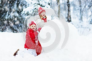 Kids building snowman. Children in snow. Winter fun.