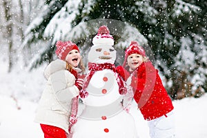 Kids building snowman. Children in snow. Winter fun