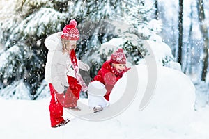 Kids building snowman. Children in snow. Winter fun.