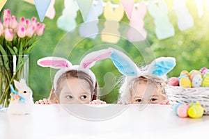 Kids with bunny ears and eggs on Easter egg hunt.