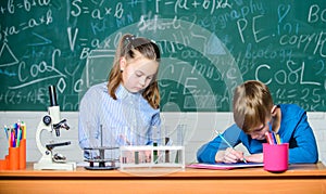 Kids busy study chemistry. School chemistry lesson. School laboratory. Girl and boy smart students conduct school