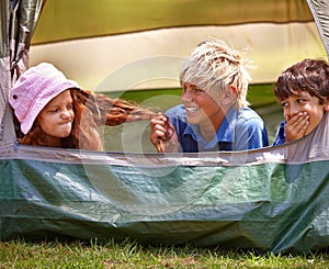 Kids, camp and outdoors for tent, friends and nature on summer vacation with boys pulling person hair. Children, annoyed