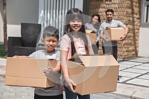 Kids with cardboard box standing in front of the house