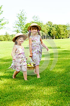 Kids carrying basket with fruit