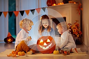 Kids carving pumpkin on Halloween. Trick or treat.