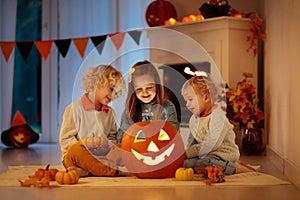 Kids carving pumpkin on Halloween. Trick or treat