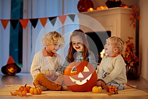 Kids carving pumpkin on Halloween. Trick or treat