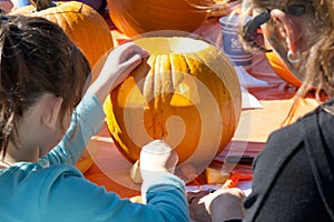 Kids carving pumpkins at Senator Scott Wieners Halloween Pumpkin Carving Event