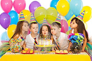 Kids celebrating birthday party and blowing