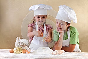 Kids with chef hats preparing tha cake dough