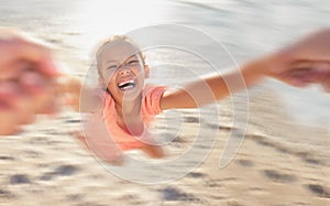 Kids, children and girl swinging on the beach while playing, laughing or having fun with a parent against the sand with