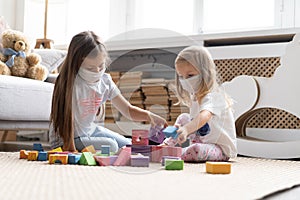 Kids children wearing mask for protect Covid-19, playing block toys in playroom.