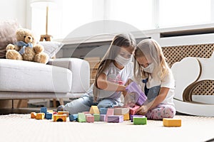 Kids children wearing mask for protect Covid-19, playing block toys in playroom.