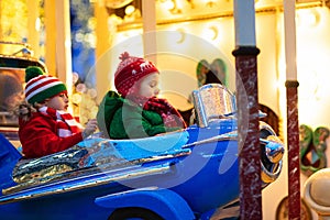 Kids at Christmas fair. Child at traditional street Xmas market in Germany. Winter outdoor fun. Little girl and boy in knitted hat