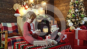 Kids with Christmas toys. The morning before New Year. Happy child with gift. Cheerful cute child opening a present.