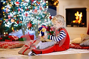 Kids at Christmas tree. Children open presents