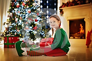 Kids at Christmas tree. Children open presents