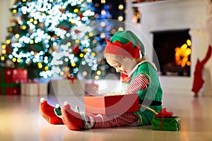 Kids at Christmas tree. Children open presents
