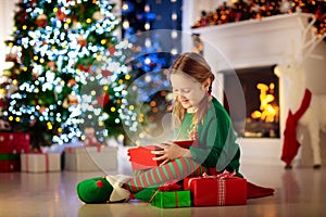 Kids at Christmas tree. Children open presents