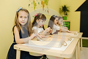 Kids in class create drawing by sand. Children use tassel for rawing. Preschool